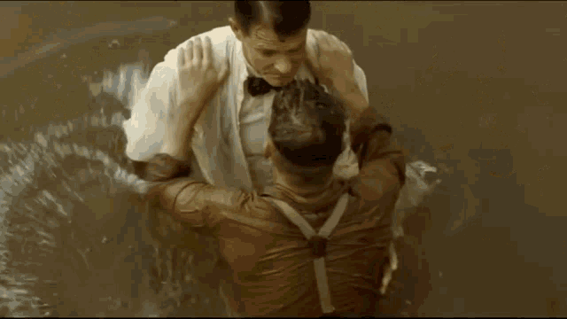 two men in overalls and suspenders are standing next to a river