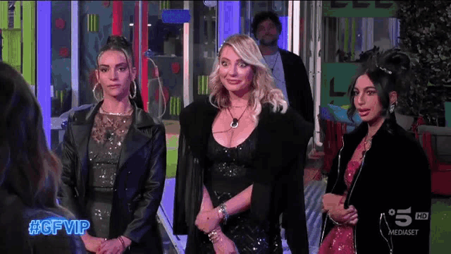 three women standing in front of a sign that says #gf vip