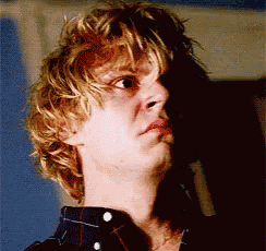 a close up of a man 's face with blonde hair and a plaid shirt