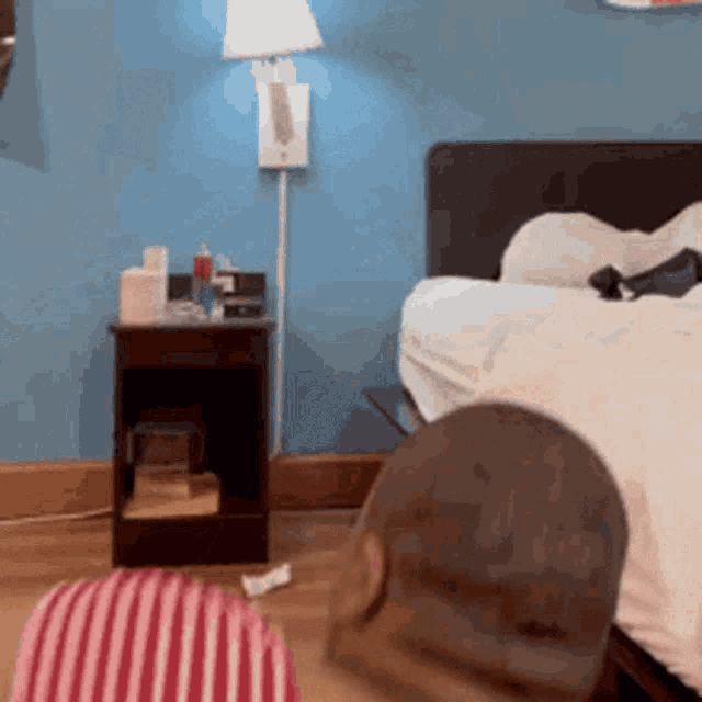 a bedroom with a bed a lamp and a night stand