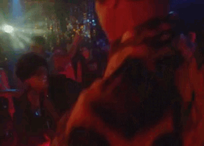a man is standing in front of a crowd of people in a dark room .