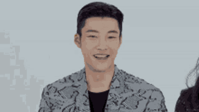 a man in a snakeskin jacket is smiling with two smiley faces behind him .