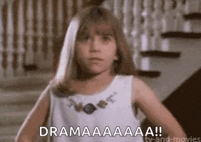 a little girl in a white dress is standing on a set of stairs and says `` dramaaaa '' .