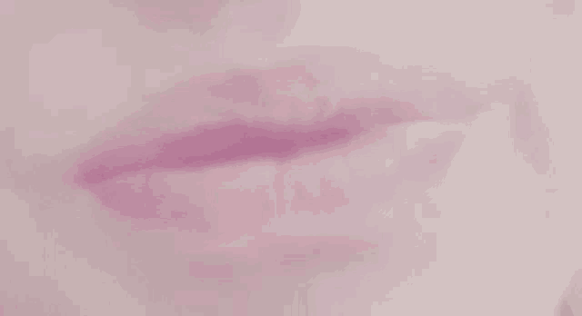 a close up of a woman 's lips with pink lipstick .