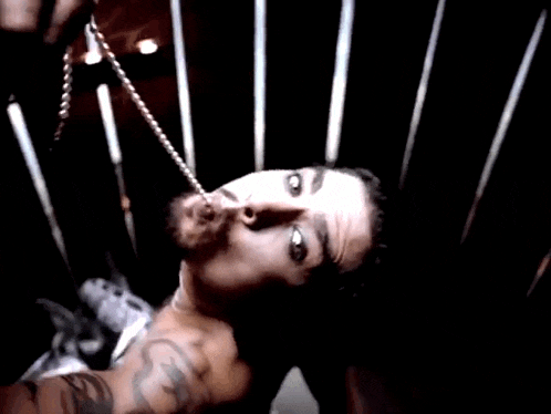 a shirtless man with a tattoo on his arm is wearing a necklace .