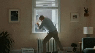 a man is looking out a window in a living room .