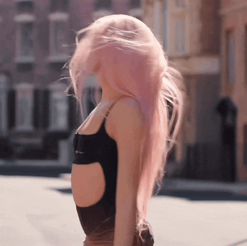 a woman with long pink hair is wearing a black tank top