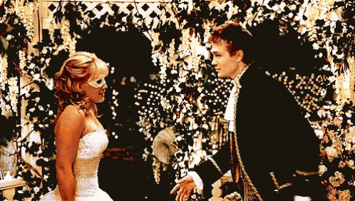 a man in a black suit and a woman in a white dress are standing next to each other