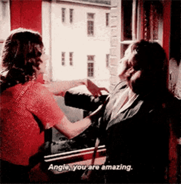 two women are standing in front of a window and one of them is saying angle you are amazing