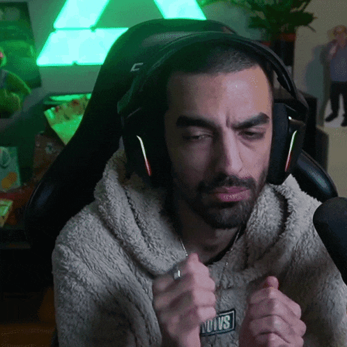 a man wearing headphones and a sweater that says aoovs