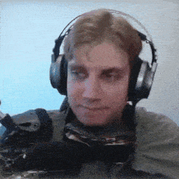 a man wearing headphones and goggles looks at the camera with a serious look on his face