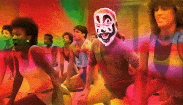a group of people are doing exercises with a man wearing a clown mask