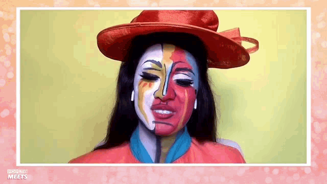 a woman with half of her face painted has a red hat on .
