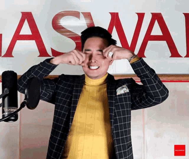 a man crying in front of a sign that says ' aswa ' on it