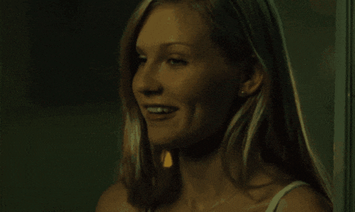 a woman is smoking a cigarette and smiling