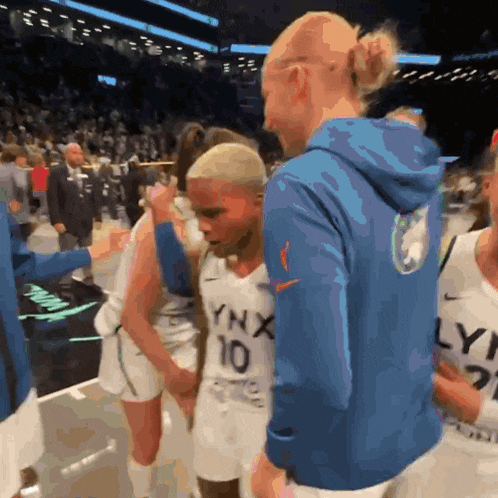 a man in a blue lynx hoodie talks to a young boy