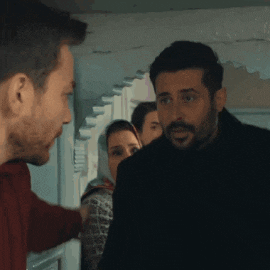 a man with a beard is standing next to another man