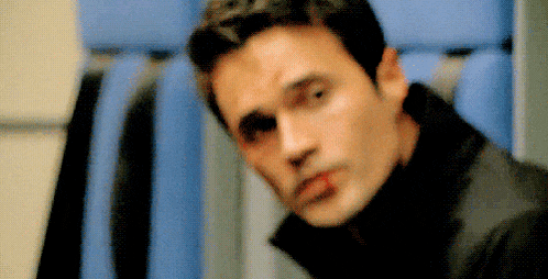 a close up of a man 's face with a red spot on his face .