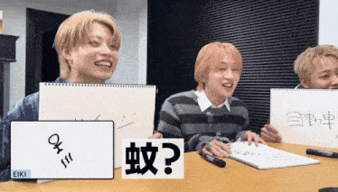 a group of young men are sitting at a table with a sign that says eiki