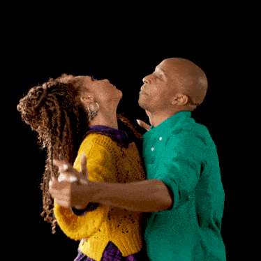 a man and a woman are dancing and the woman is wearing a yellow sweater