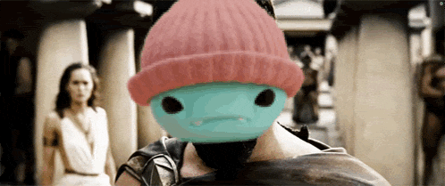 a person wearing a pink beanie with a blue face on it