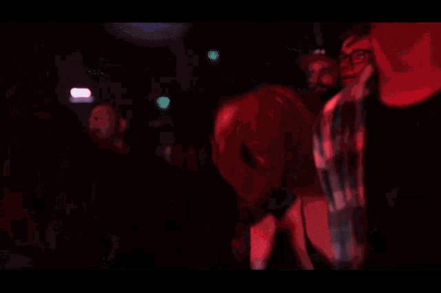 a woman wearing a black shirt that says ' apocalypse ' on it stands in a crowd