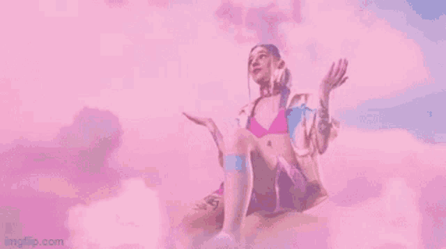 a woman in a pink bikini is sitting on a cloud in the sky .
