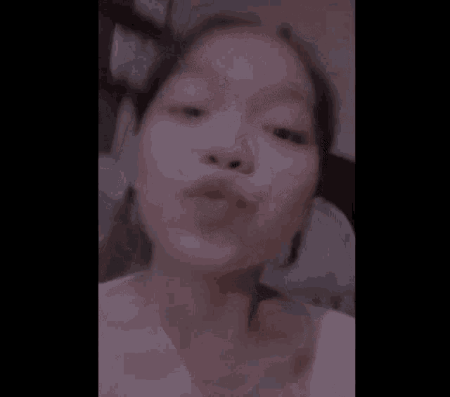 a close up of a girl 's face with a pink lip .