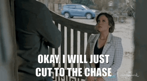 a woman is standing in front of a fence talking to a man and says okay i will just cut to the chase