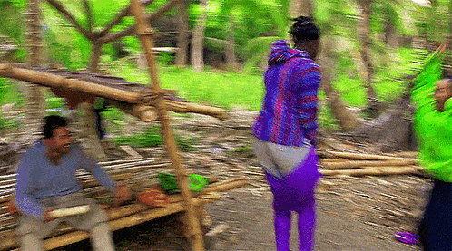 a blurry picture of a man in a blue shirt and a woman in purple pants