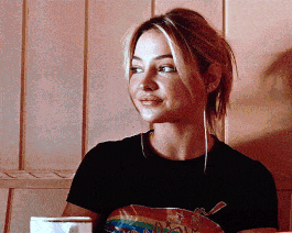 a woman sitting at a table with a cup of coffee
