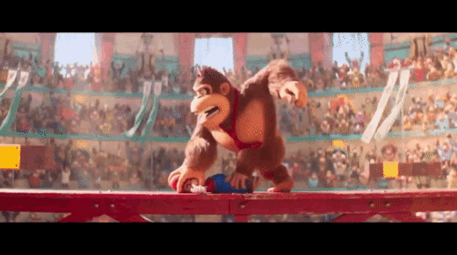 donkey kong is standing on a wooden railing in front of a crowd of people .