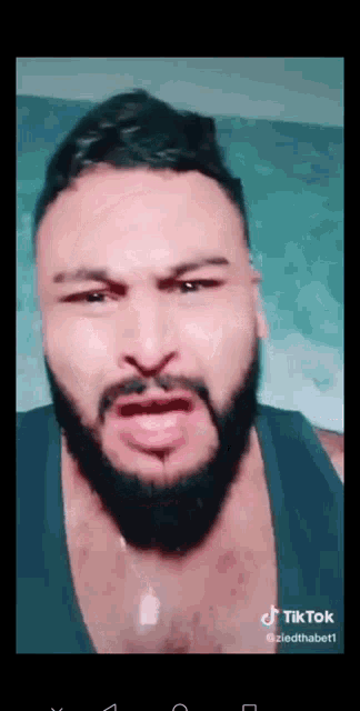 a man with a beard is making a funny face on a tiktok video