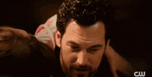 a close up of a man and woman kissing with a cw logo in the background