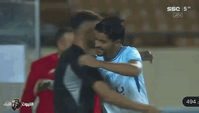 a soccer player is hugging another player on a television screen that says ssc