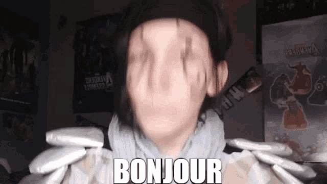 a man in a hat is holding a bunch of packets and says bonjour