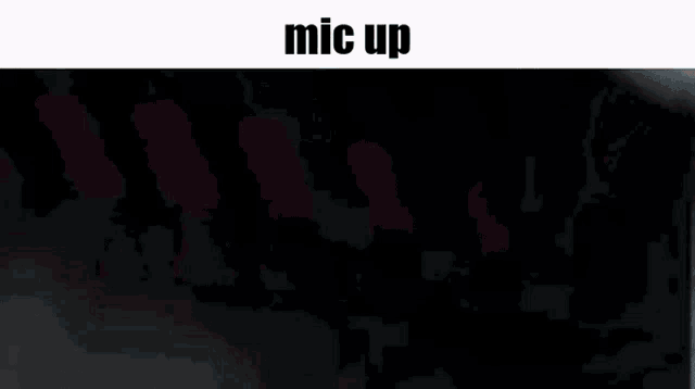 a man wearing headphones and a microphone with the words mic up above him