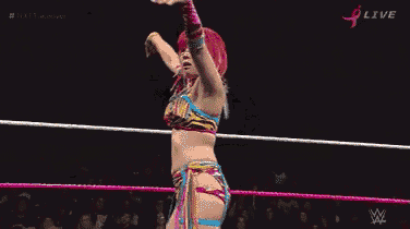 a woman in a wrestling ring with a referee watching