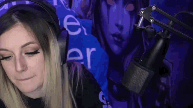 a woman wearing headphones and a microphone is sitting in front of a purple wall .