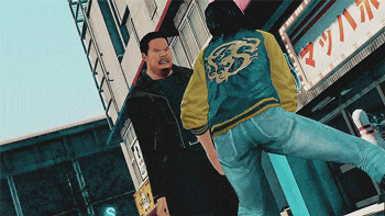 a man in a blue jacket with a dragon on the back is standing next to another man
