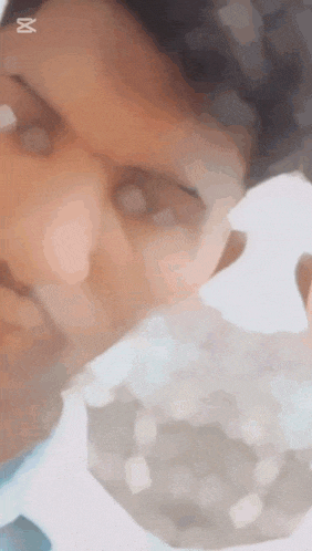 a close up of a person 's face with the letter x on the bottom right
