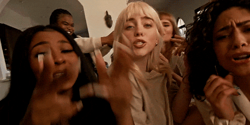 billie eilish is surrounded by a group of girls