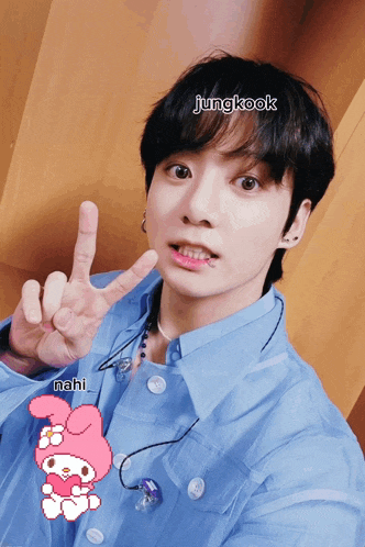 a young man in a blue shirt giving a peace sign with the name jungkook written above him