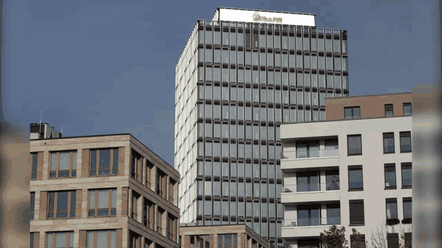 a tall building with a red and white sign on top that says ' allianz '