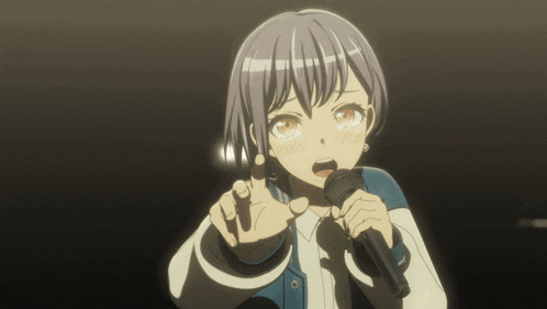 a girl is singing into a microphone and making a face