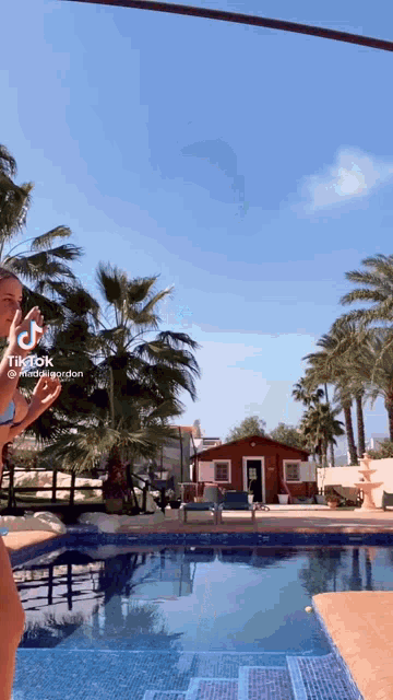 a woman in a bikini is standing next to a swimming pool with a tiktok watermark on the bottom