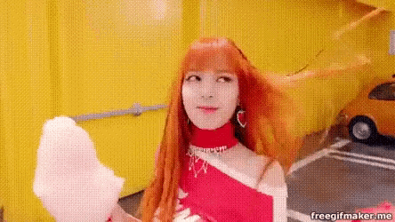 a woman with red hair is holding a pink cotton candy in her hand .