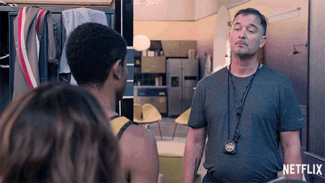 a man in a grey shirt with a netflix logo on the bottom right