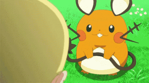 a pokemon is sitting in the grass next to a person holding a yellow ball .
