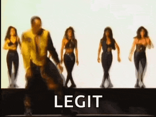 a man is dancing in front of a group of women and the word legit is on the screen .